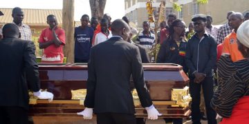 Bobi looks on as Uganda Uganda Funera; Services carries the casket containing the remains of his dad.