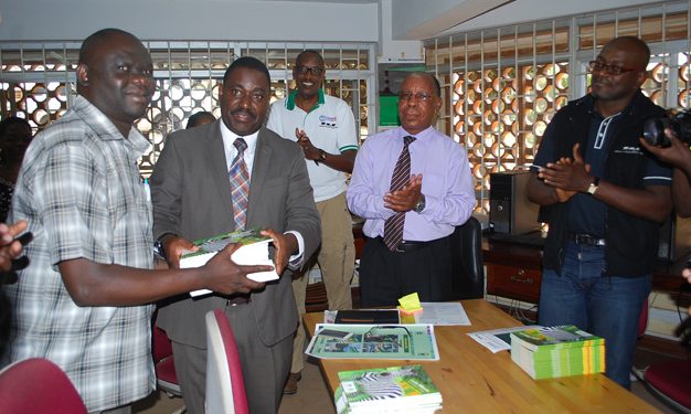 Dr Andrew Seguya ED Uganda Wild life Authority hands over books to Mr Wilson Adriko Librarian MUST as Dean of students Emmanuel Kyagaba and Mr Charly.