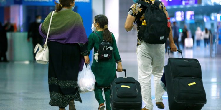 A family walks with their bags upon arrival at Frankfurt Airport, Germany, August 18, 2021, after being evacuated from Kabul, Afghanistan. REUTERS/Thilo Schmuelgen
