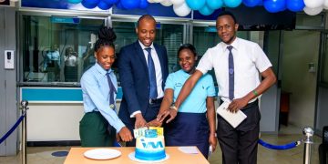 Head of Treasury, Denis Damba cutting cake with Acacia branch team during the CSW.